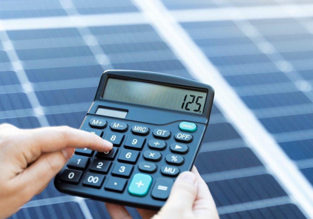 Someone is calculating the savings of use a solar panel system with a calculator